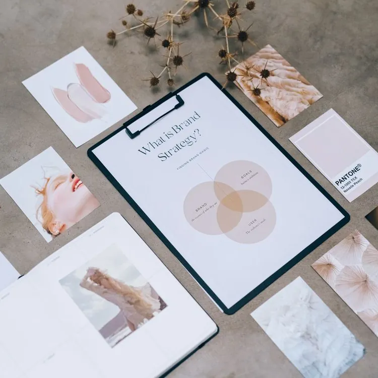 Planche d'inspiration de stratégie de marque : moodboard, nuancier et carnet sur un plan de travail